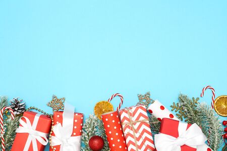 Gift boxes with christmas ornaments and fir tree branches on blue backgroundの写真素材
