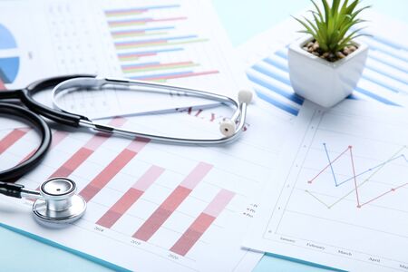 Financial papers with stethoscope and green plant in potの写真素材