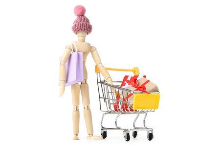Wooden figure with paper bag and gift boxes in shopping cartの写真素材