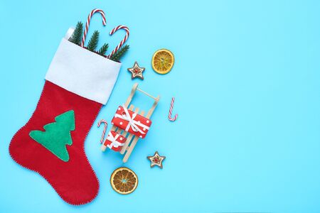 Red stocking with christmas ornaments and candy canes on blue backgroundの写真素材