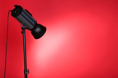 Studio lighting with tripod on red backgroundの写真素材
