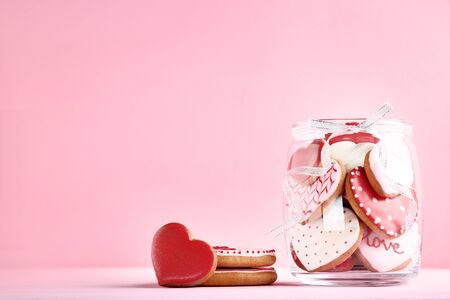 Valentine day cookies in glass jar on pink backgroundの写真素材