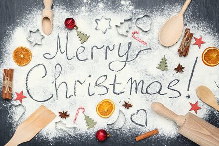 Text Merry Christmas on flour with ornaments and kitchen utensilsの写真素材