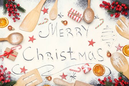 Text Merry Christmas on flour with kitchen utensils and ornamentsの写真素材