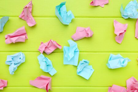 Colorful crumpled paper balls on green wooden tableの写真素材