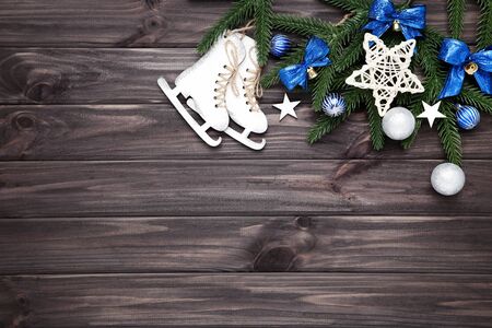Christmas tree branches with toys and small skates on wooden tableの写真素材
