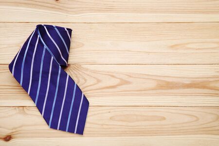 Striped necktie on brown wooden tableの写真素材