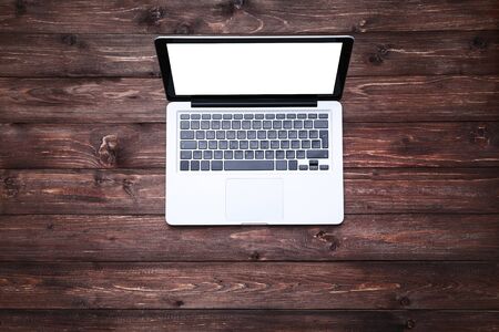 Laptop computer on brown wooden tableの写真素材