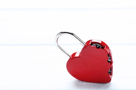Red heart shaped padlock on wooden tableの写真素材