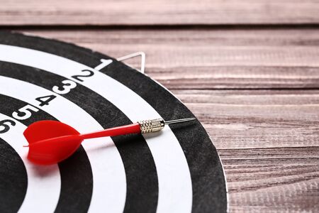Dartboard with darts on brown wooden tableの写真素材