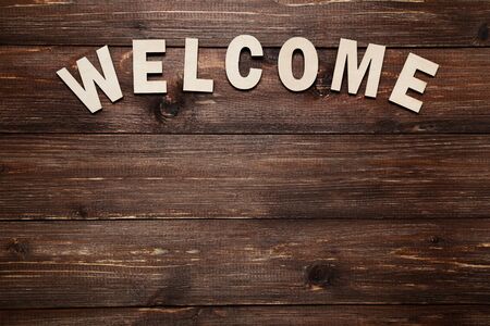 Word Welcome by wooden letters on brown tableの写真素材