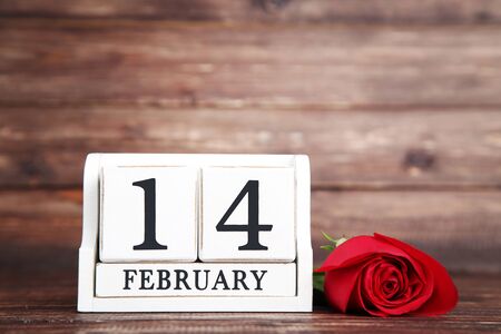 Red rose with wooden calendar on brown backgroundの写真素材