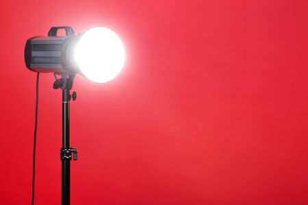 Studio lighting with tripod on red backgroundの写真素材