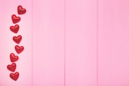 Valentine red hearts on pink wooden background