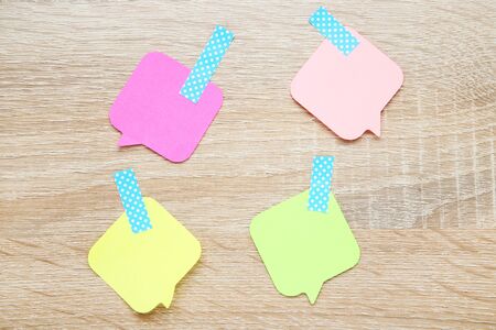 Paper speech bubbles on wooden table