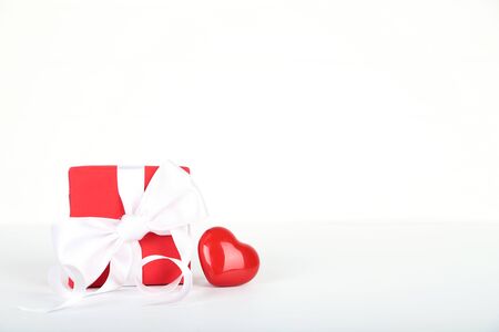 Gift box with ribbon and heart on white backgroundの写真素材