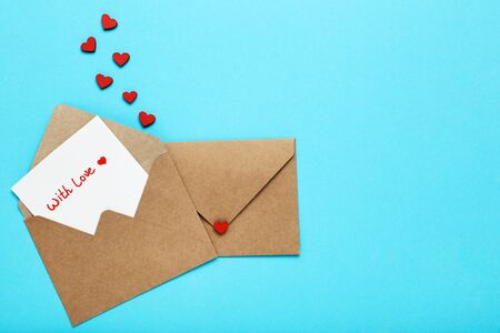 Paper envelopes with red hearts and text With Love on blue background