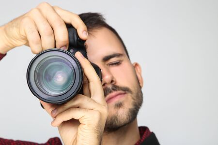 Young photographer with camera on blue backgroundの写真素材