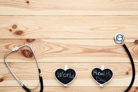 Stethoscope with text World Health Day on brown wooden tableの写真素材