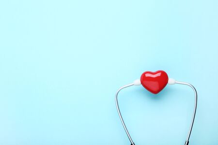 Stethoscope with red heart on blue background