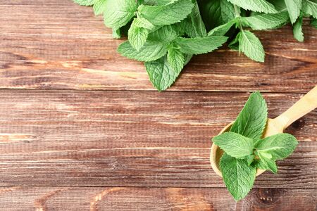 Mint leafs with spoon on brown wooden tableの写真素材