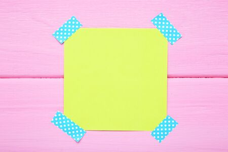 Paper sticky note on pink wooden table