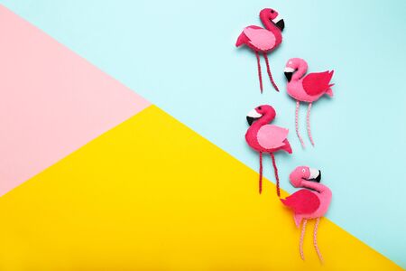 Soft toy of flamingos on colorful paper backgroundの写真素材