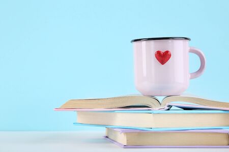 Red heart with pink mug and book on blue backgroundの写真素材