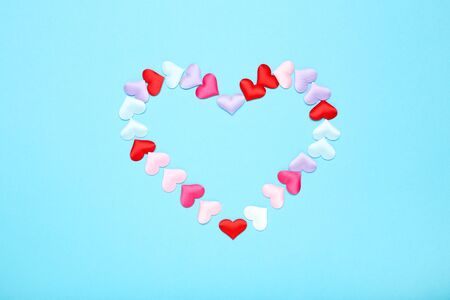 Colorful small hearts on blue background