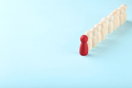 Leader concept. Wooden figures on blue background