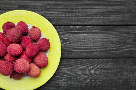 Tasty lychee in plate on black wooden tableの写真素材