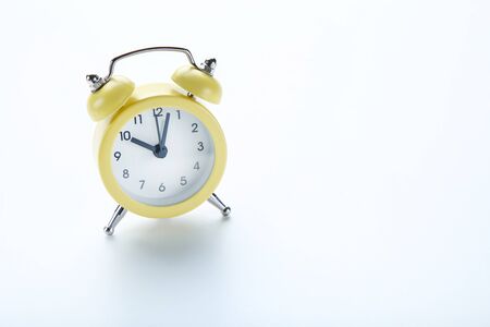 Yellow alarm clock on white background