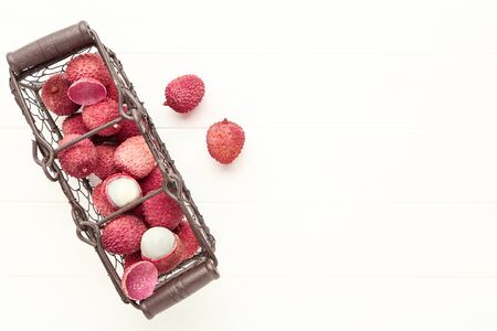 Tasty lychee in basket on white wooden tableの写真素材