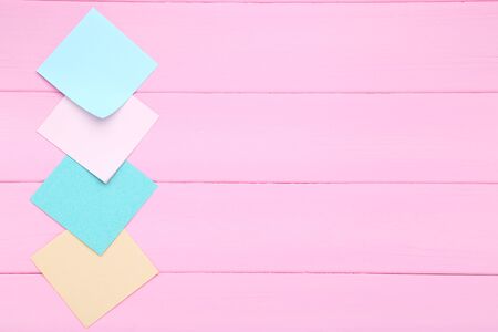 Paper sticky notes on pink wooden table