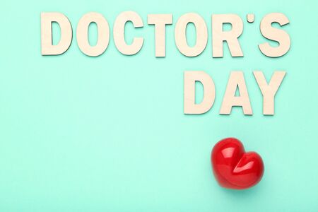 Text Doctor's Day with red heart on mint backgroundの写真素材
