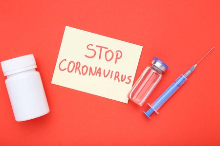 Text Stop Coronavirus with injection and syringe on red backgroundの写真素材