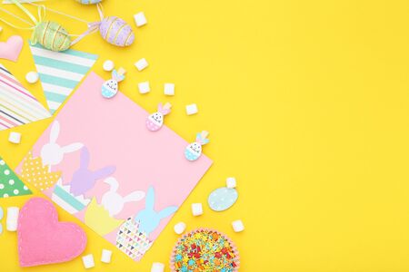 Easter concept. Greeting card with sprinkles, marshmallows and eggs on yellow backgroundの写真素材