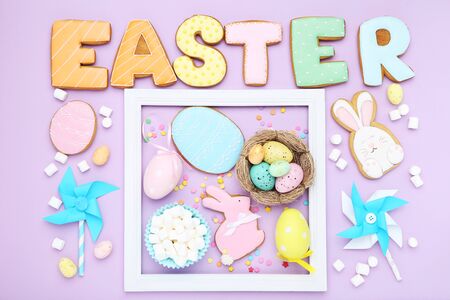 Word Easter by cookies with marshmallows and eggs on purple background