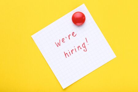 Text We Are Hiring on paper on yellow backgroundの写真素材