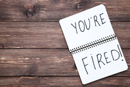 Text You Are Fired in notepad on brown wooden tableの写真素材