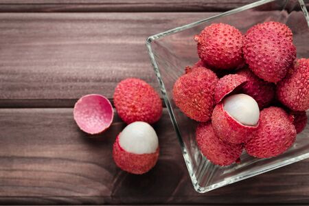 Tasty lychee in glass bowl on wooden tableの写真素材