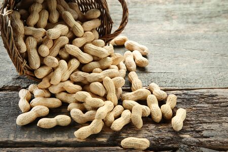 Peanuts in basket on grey wooden table