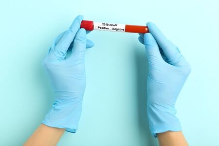 Coronavirus concept. Female hands holding test tube with blood
