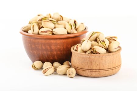 Tasty pistachios in bowls on white backgroundの写真素材