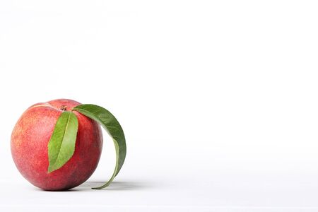 Fresh peach with green leaf on white background