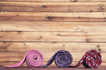 Colorful neckties on brown wooden tableの写真素材
