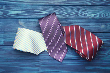 Colorful neckties on blue wooden table