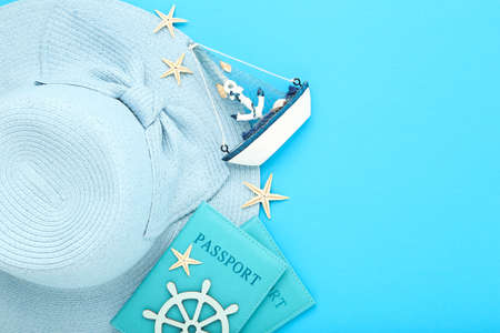Summer straw hat with passports, starfishes and decorative ship on blue backgroundの写真素材