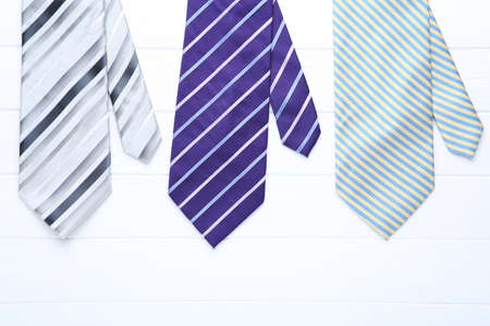 Colored neckties on white wooden tableの写真素材