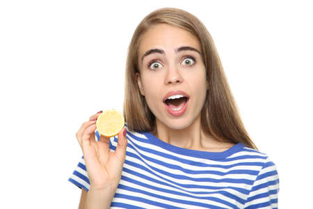 Young girl holding piece of lemon on white background